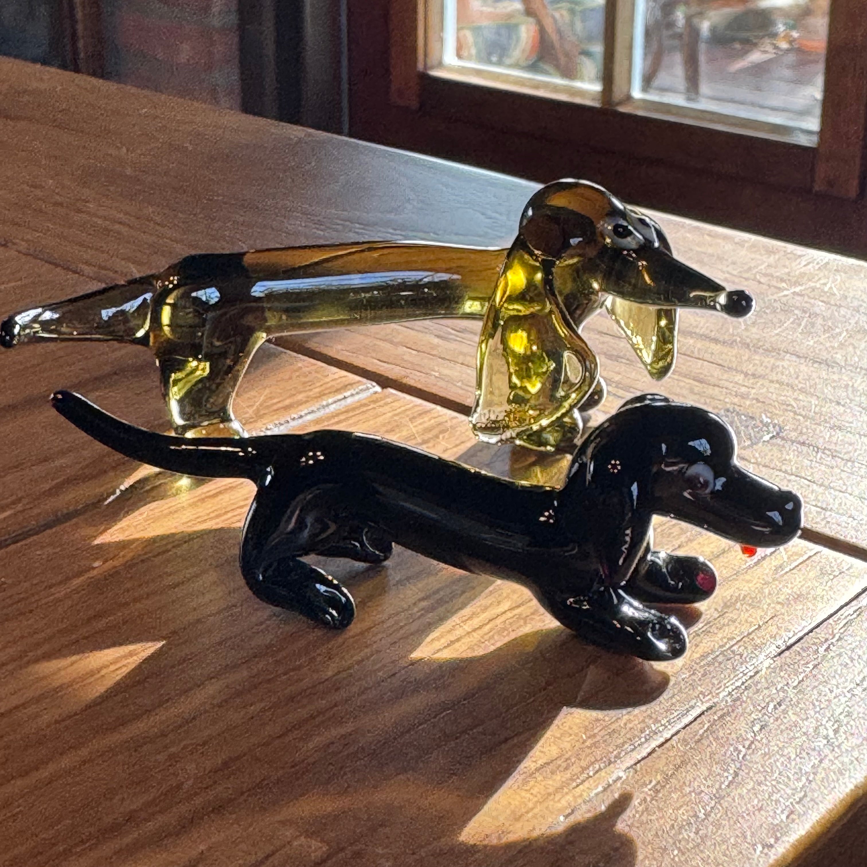 Set aus 2 Dackeln aus Glas – mundgeblasen im Murano-Stil – schwarz und bernsteinfarben.