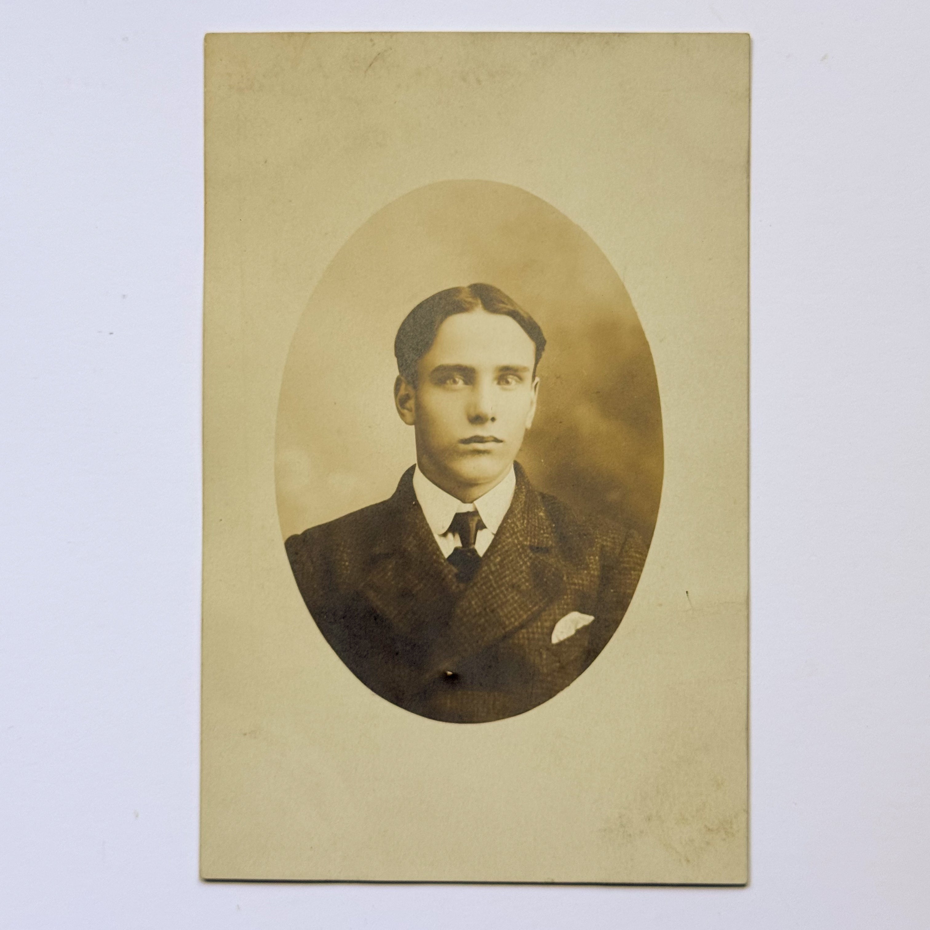 Portrait of a young man in an oval frame - British postcard (c. 1915)