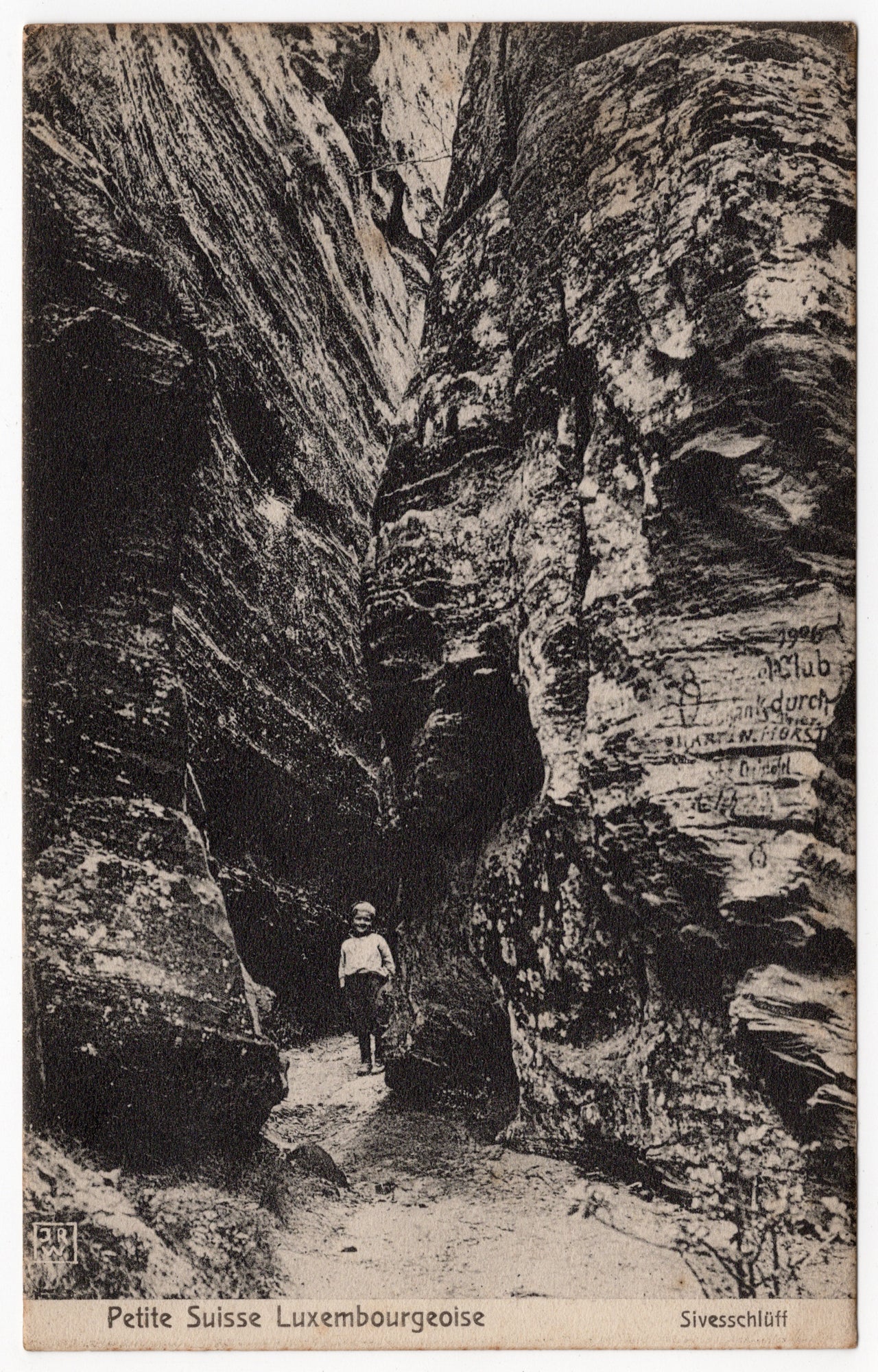 Zwart-wit ansichtkaart Sivesschlüff Petite Suisse luxembourgeoise, kind in rotsspleet met 1906-inkervingen, uitgave Waeger Echternach