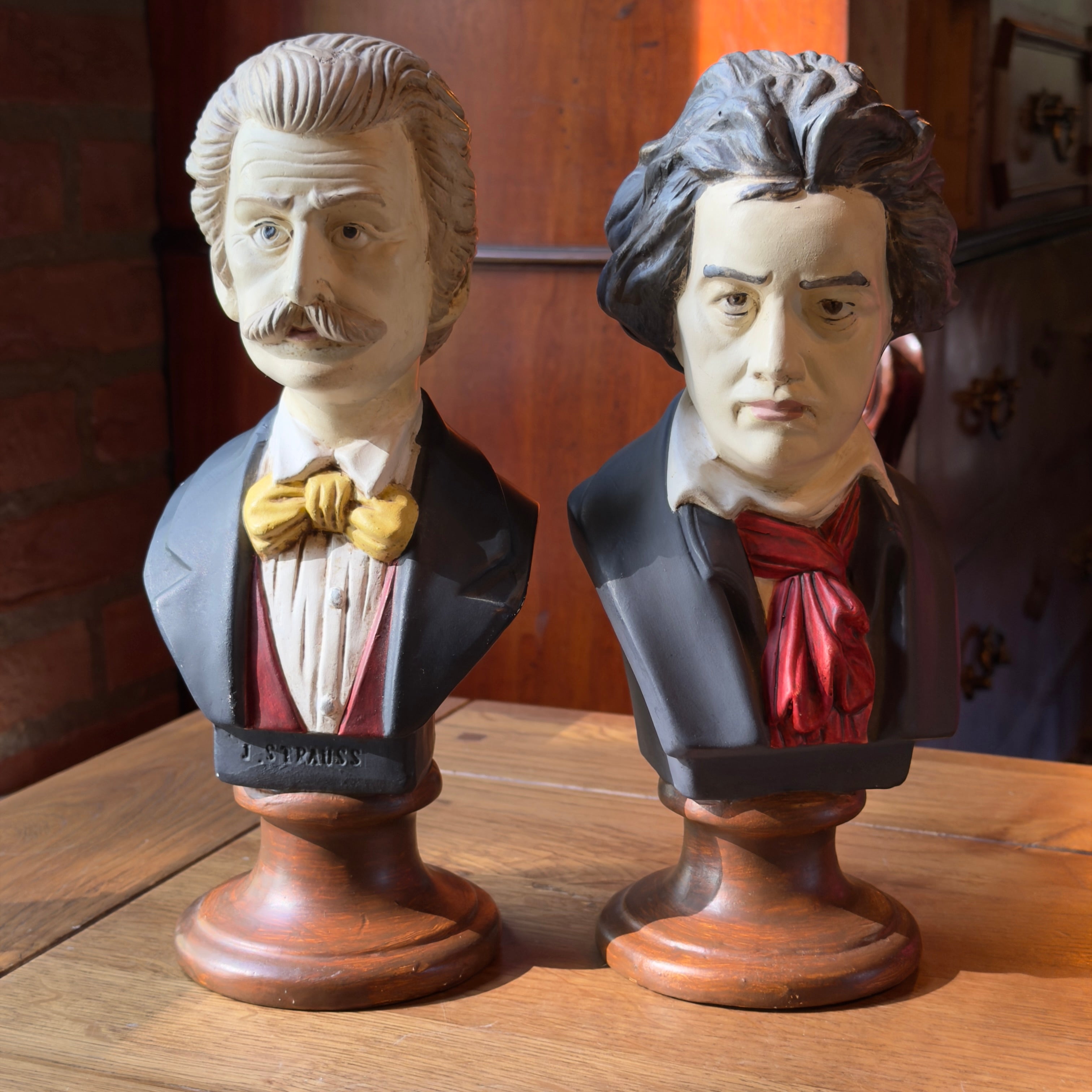 Set van twee beschilderde gipsen bustes Johann Strauss en Ludwig van Beethoven op houtkleurige ronde voet, twintigste eeuw