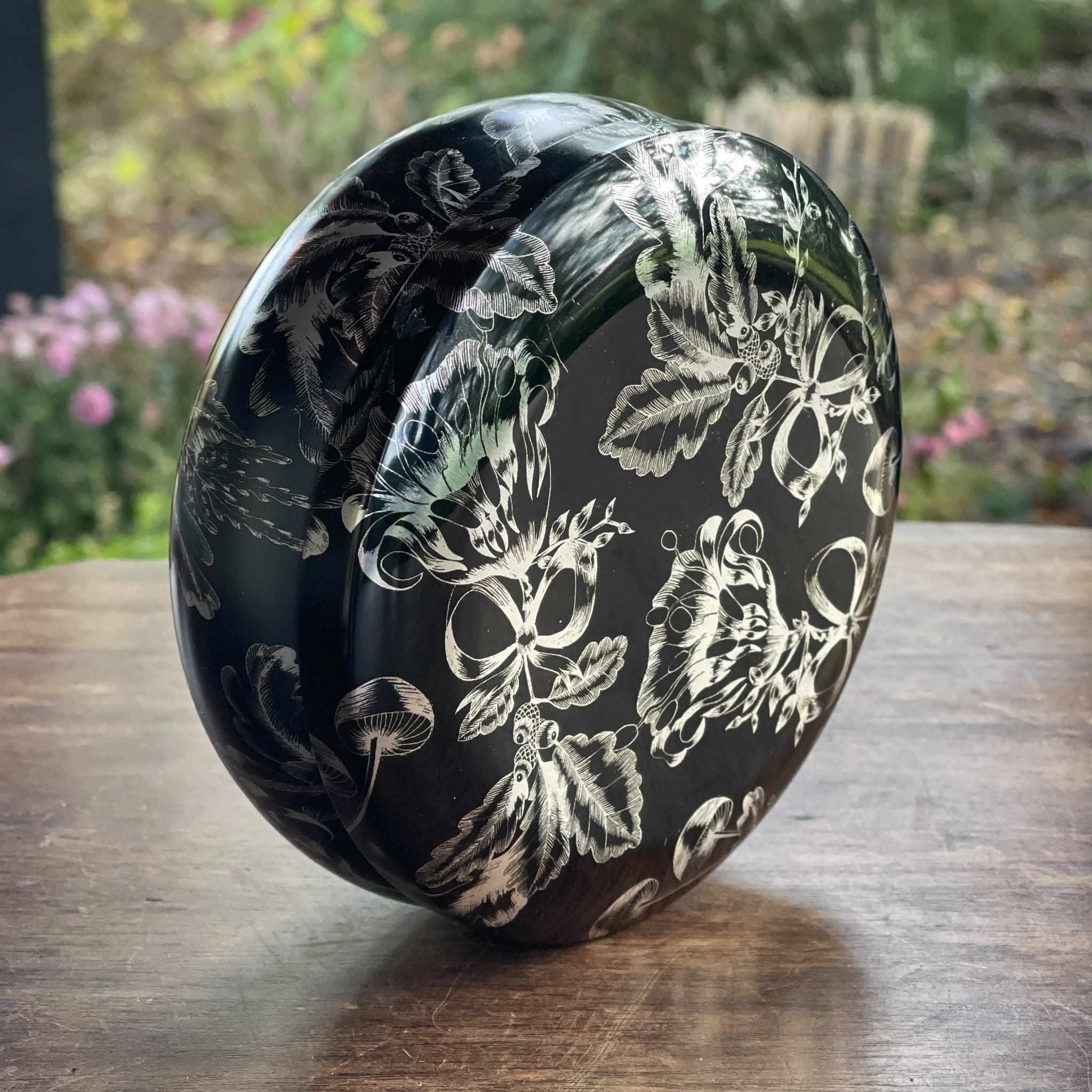 Rond zwart metalen blik met zilverkleurige bloemendecoratie - The Collectionist