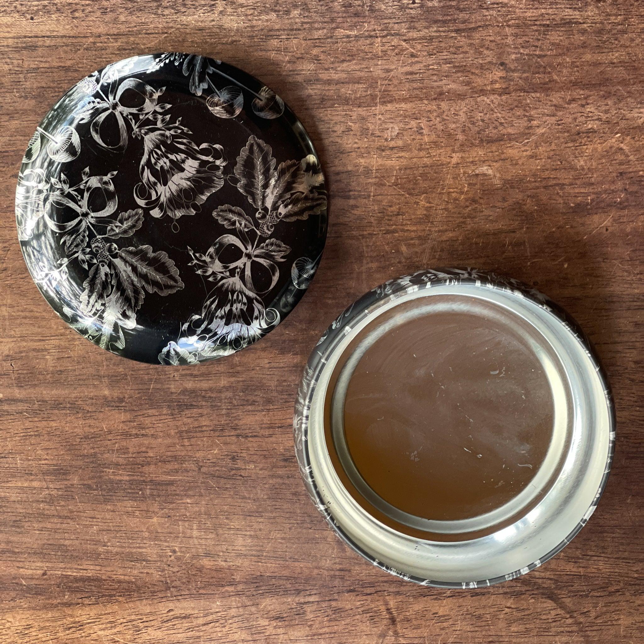 Rond zwart metalen blik met zilverkleurige bloemendecoratie - The Collectionist