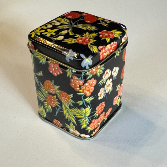 Vintage theeblik met bloemen en bessen