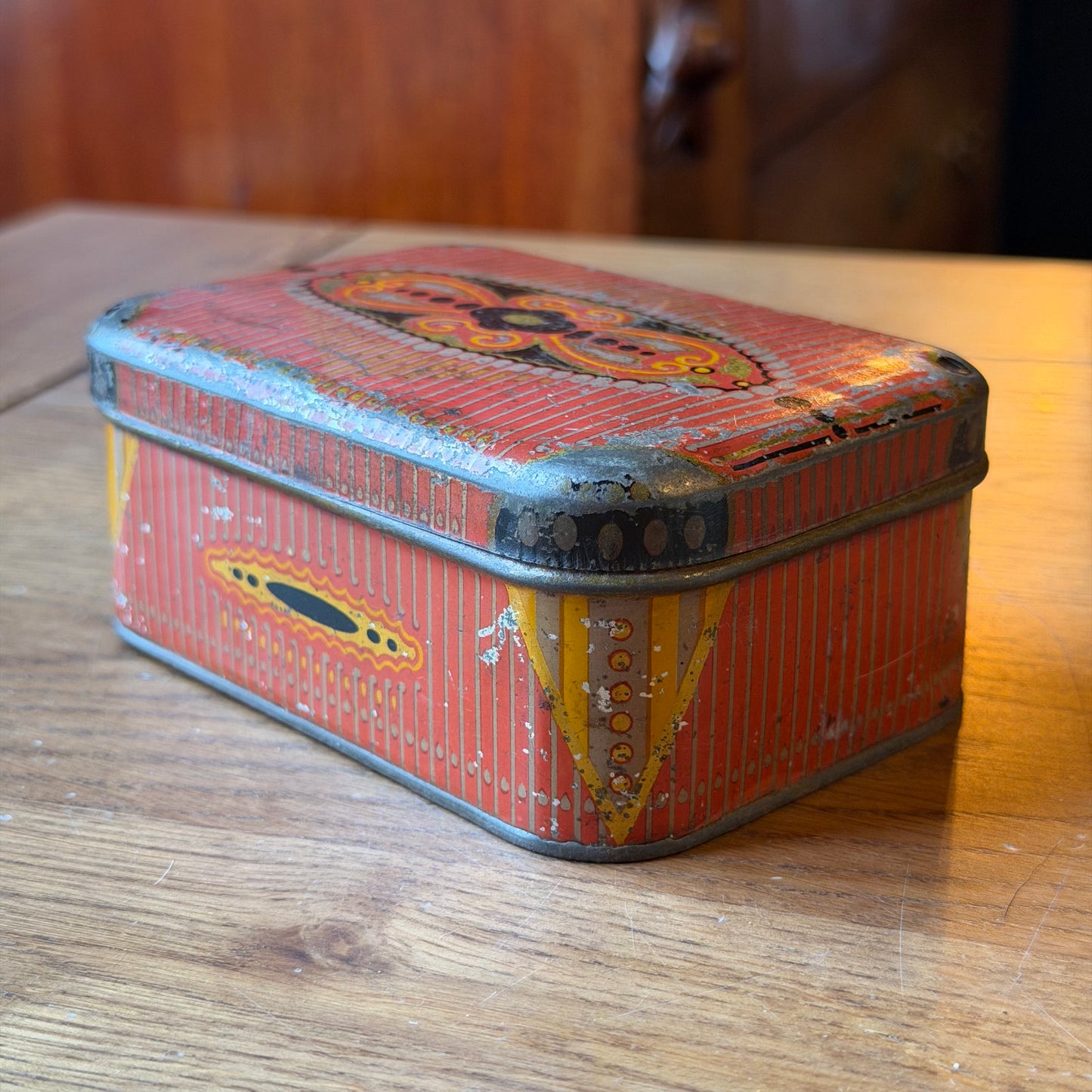 Old rectangular red tin with decorative pattern