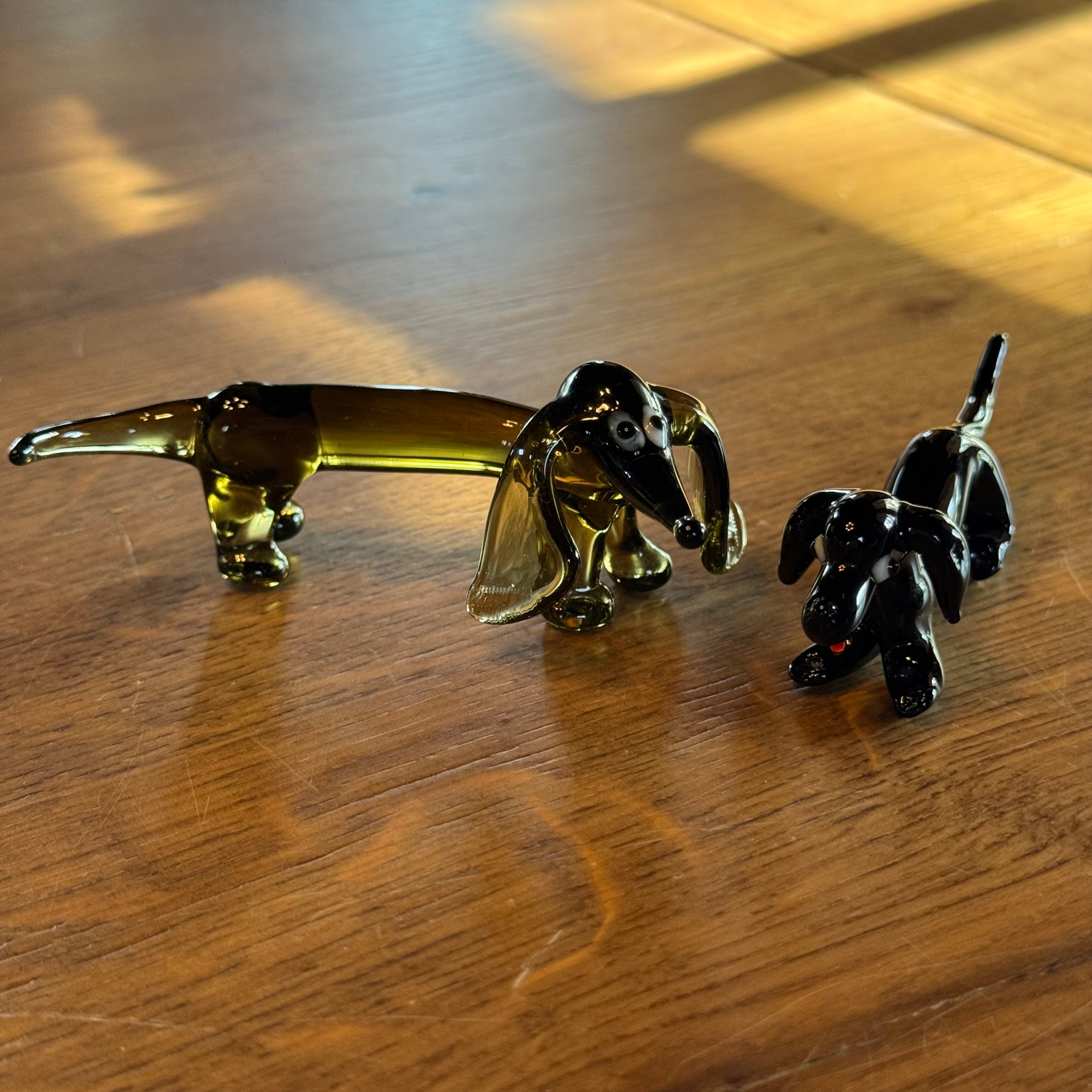Set aus 2 Dackeln aus Glas – mundgeblasen im Murano-Stil – schwarz und bernsteinfarben.