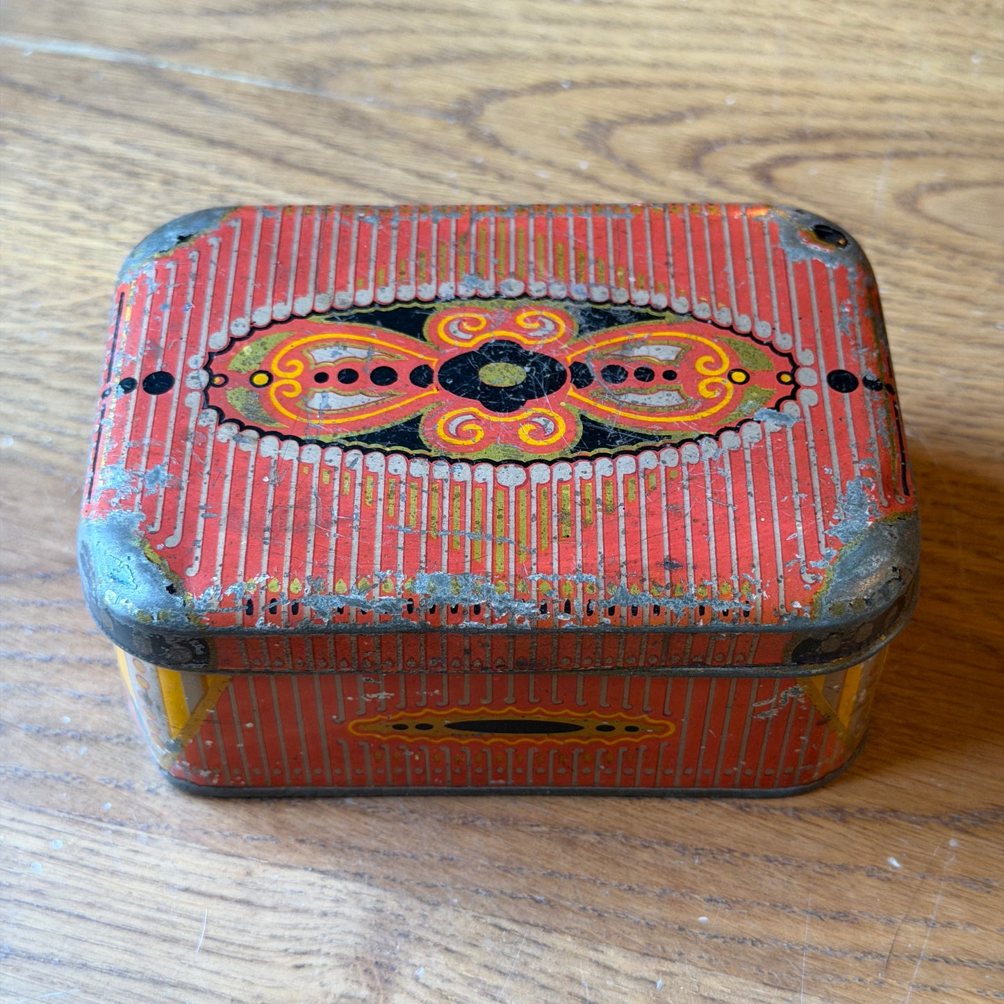 Old rectangular red tin with decorative pattern