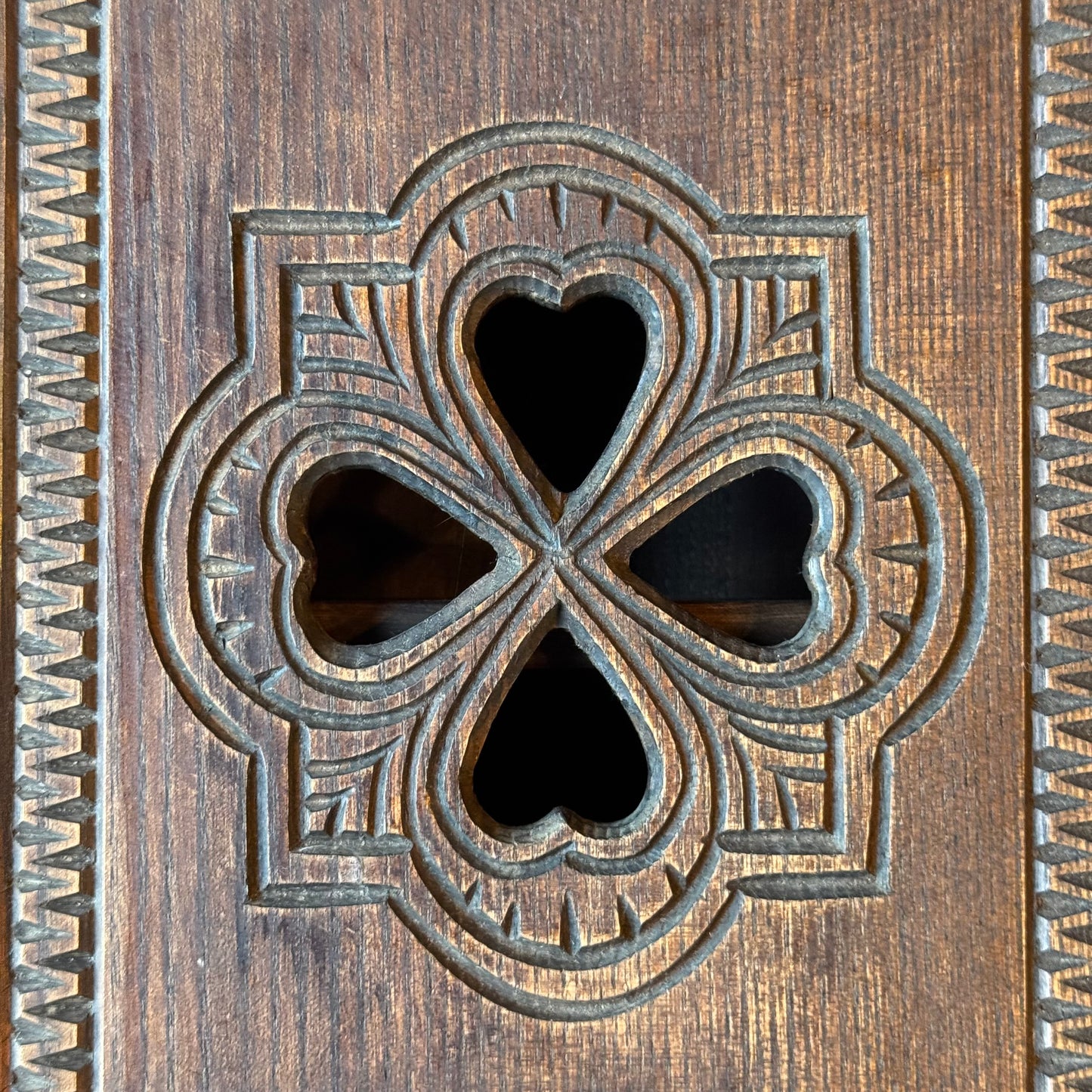 Wooden wall cabinet with carved clover pattern