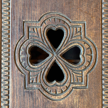 Wooden wall cabinet with carved clover pattern
