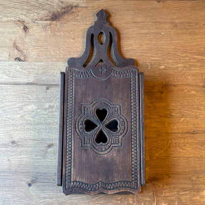 Wooden wall cabinet with carved clover pattern