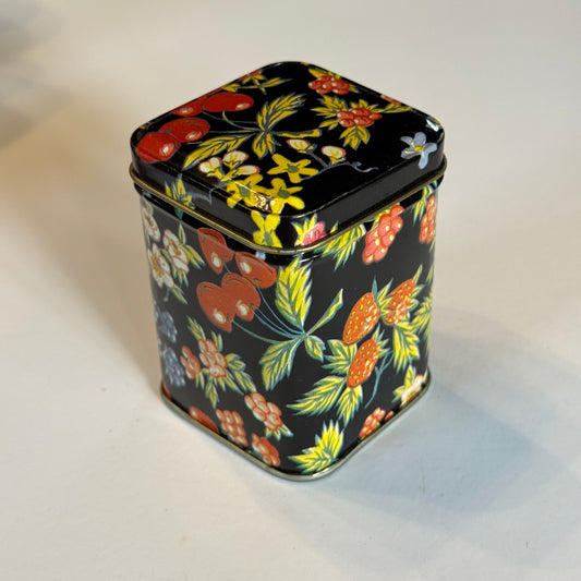 Vintage theeblik met bloemen en bessen