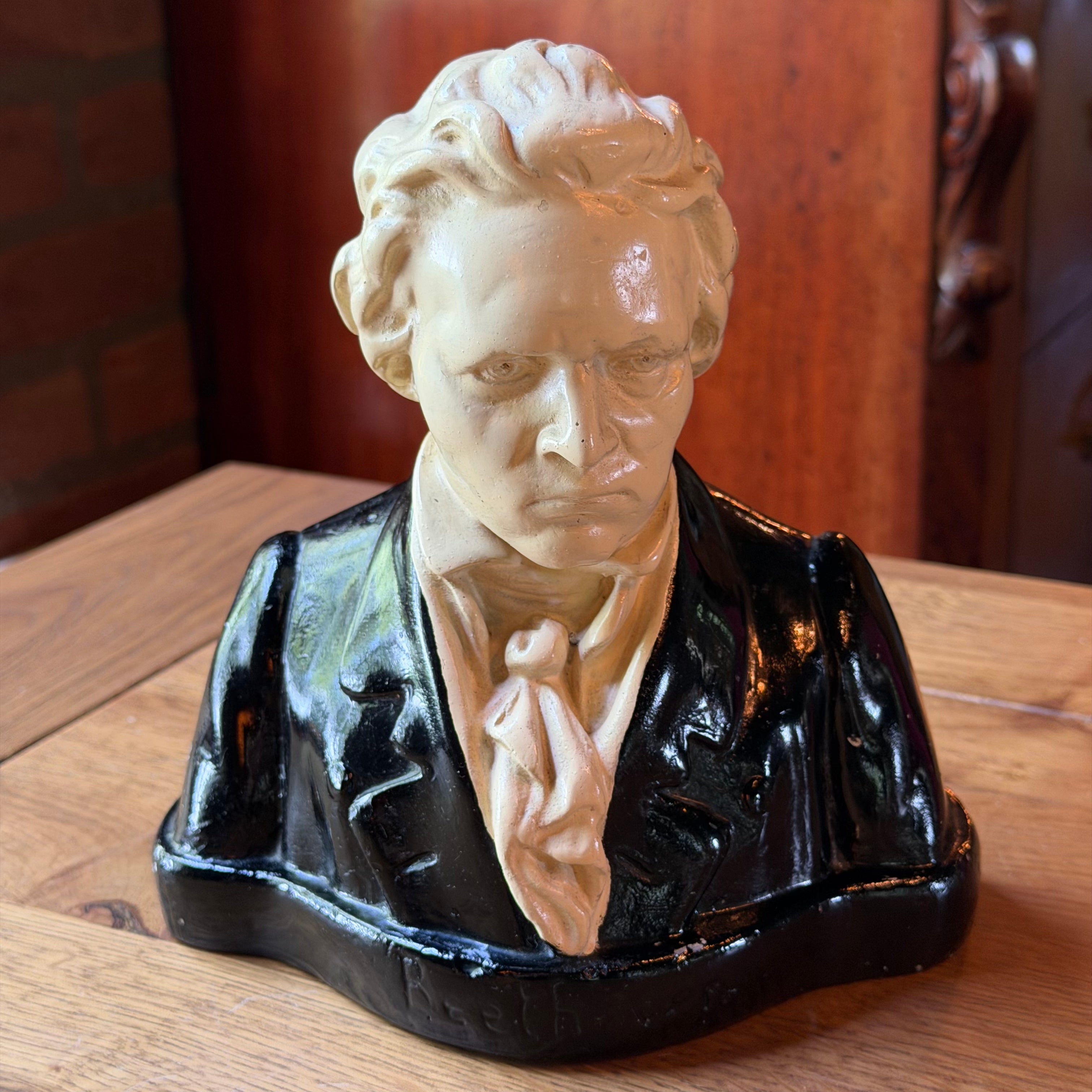 Beschilderde gipsen buste van Ludwig van Beethoven, crème hoofd en zwart gelakte jas op sokkel, circa 1930