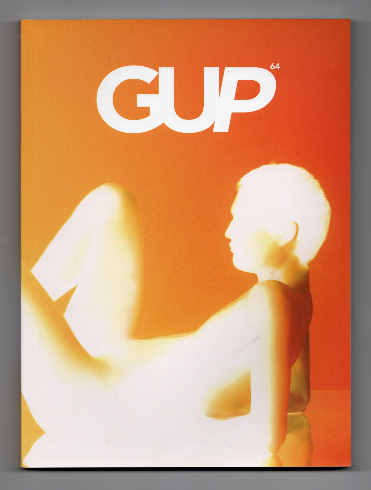 Cover GUP Magazine 64 The Silhouette Issue uit 2020 met fotografie door Igor Pjorrt van zittende figuur in oranje en wit licht.